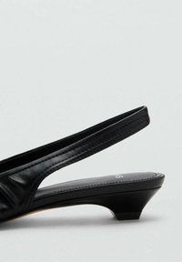 Mustat nahkaiset slingback-korkokengät, joissa on lyhyt lohkokorko. Yläosas on rypistetty rakenne. Sujuva, kontrastivärinen musta sisäpohja.