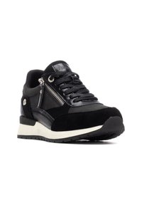 Zapatilla negra con una combinación de ante y materiales sintéticos, presenta cordones y un cierre lateral, suela blanca y puntera texturizada.
