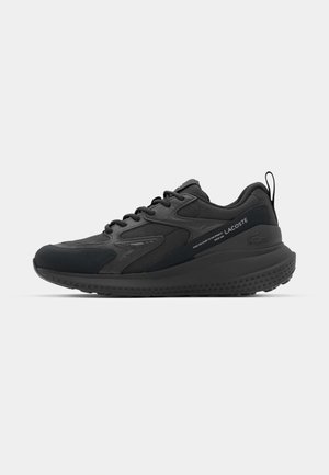 Black athletic sneakers featuring a mix of materials, textured accents, a cushioned sole, and branding on the side. Overall streamlined design.