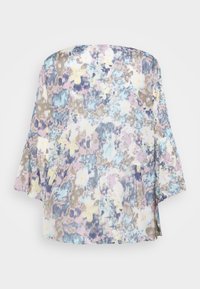 Blouse légère à imprimé floral avec des couleurs pastel (bleu, rose, jaune), des manches bouffantes et un ourlet froncé pour la texture.