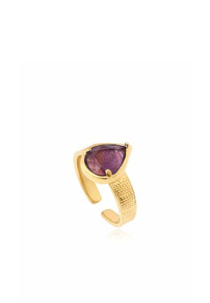 Bague ajustable en or avec une bande texturée et une grande pierre précieuse violette taillée en forme de goutte.