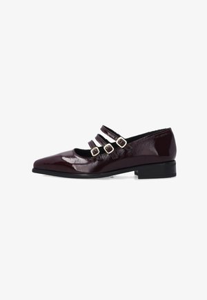 Chaussure en cuir verni bordeaux avec un bout pointu, trois brides décoratives et un petit talon carré. Texture lisse, design minimaliste.