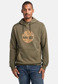 Felpa verde oliva con tasca a marsupio e polsini a coste, con un grande logo beige di un albero sul petto. Vestibilità casual.