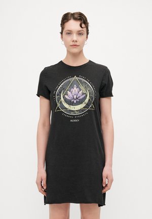 Svart bomulls t-shirt klänning med rundad halsringning och korta ärmar. Har ett grafiskt tryck av en lotus omgiven av geometriska former.