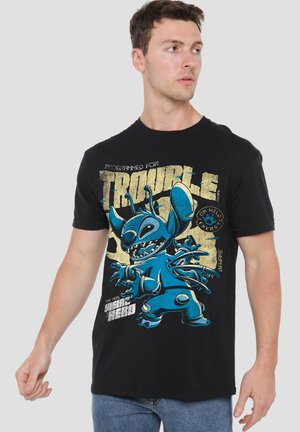 Black cotton t-shirt featuring a blue cartoon character graphic with the text "PROGRAMMED FOR TROUBLE" and "THE REAL HERO" in bold colors.