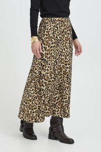 Leopard print maxi skirt in lightweight fabric with an elastic waistband, flowing silhouette, and detailed with pleats; paired with black boots.