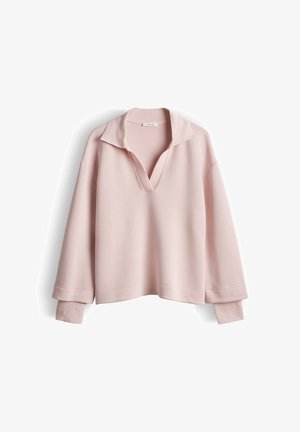 Pull rose clair à manches longues avec un col en V profond et un col et des poignets côtelés, présenté sur un fond blanc.