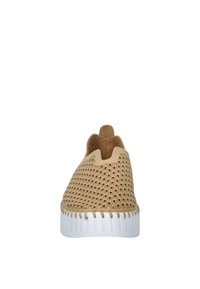 Tan instapper met een getextureerde, geperforeerde bovenkant, ronde neus en witte outsole met subtiele ribbels. Minimalistisch ontwerp zonder sluitingen.
