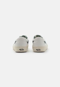 Sneaker basse bianche con dettagli verdi. Upper in pelle liscia, suola in gomma e tallone con logo. Design classico con lacci.