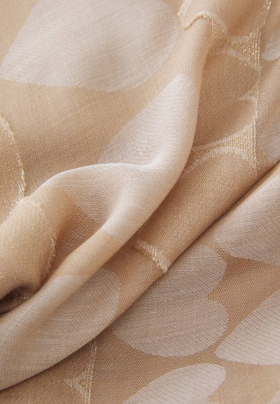 Beige fabric with a subtle sheen features large, light-colored floral patterns. The texture is smooth and lightweight, showing delicate weave details.
