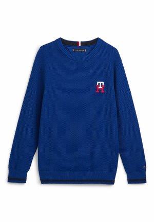 Pull en tricot texturé bleu avec col rond, poignets et ourlet côtelés, et logo "TH" rouge et blanc sur la poitrine.