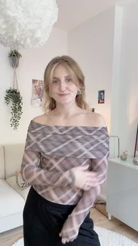 Õlavarrest vabalt langev, pikkade käistega top, mis on valmistatud läbipaistvast kangast, millel on lillaka ja beeži ruuduline muster. Must elastne vöökohtadega seelik.