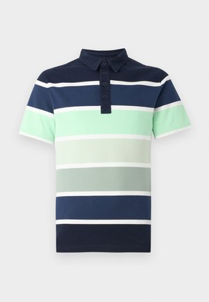 Laivastonsininen ja mintunvihreäraitainen lyhythihainen poolopaita, yhdistetty laivastonsinisiin shortseihin. Asun täydentävät mustat loafersit ja valkoiset nilkkasukat.