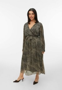 Robe longue noire et beige avec un décolleté en V, des manches longues et une taille froncée. Présente un motif de rayures ondulées et une texture transparente.