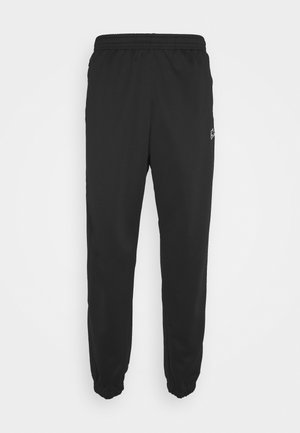 Schwarze Jogginghose mit elastischem Bund, zulaufenden Beinen und elastischen Bündchen, mit kleinem Logo am oberen linken Oberschenkel.
