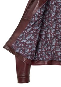 Giacca di pelle bordeaux con fodera interna grigia caratterizzata da un motivo ripetitivo di disegni bordeaux e grigi. Chiusura con zip e vestibilità su misura.