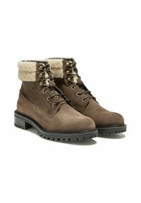 Bottines en daim marron avec un revers en fausse fourrure crème, des œillets en métal et des semelles en caoutchouc noir dotées d'un motif à crampons pour l'adhérence.