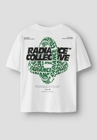 Camiseta de algodón blanca con texto en negrita negro y verde. El diseño gráfico incluye un patrón circular y una cita motivacional. Mangas cortas.