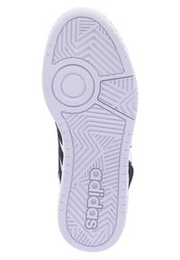 Adidas sneakersål med en struktureret hvid gummiydersål, der har et zigzag-mønster og cirkulært designelement. Sort overdel synlig ved kanterne.