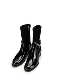 Czarne skórzane botki za kostkę z błyszczącym wykończeniem, z czarną zamszową cholewką, bocznym zamkiem błyskawicznym oraz akcentem w postaci srebrnego łańcucha.
