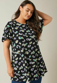 Top negro con estampado floral que presenta mangas cortas acampanadas, flores blancas, verdes y moradas, cuello redondo y un corte holgado, fabricado en tejido suave.
