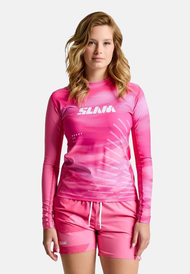 Rosa Langarm-Rashguard mit gepunktetem Muster und Logo, kombiniert mit passenden rosa Shorts mit Kordelzug und dezentem Branding.