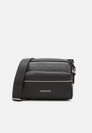 Sac à épaule noir Valentino avec poche zippée à l'avant, bandoulière réglable et logo Valentino sur le tissu et le panneau avant.