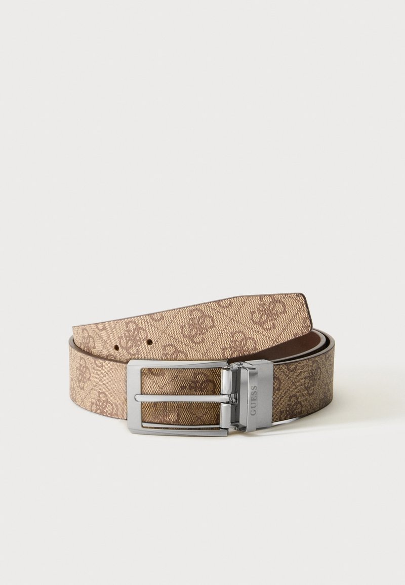 Ceinture beige Guess avec un motif logo brun répétitif et une boucle rectangulaire argentée sur fond blanc.