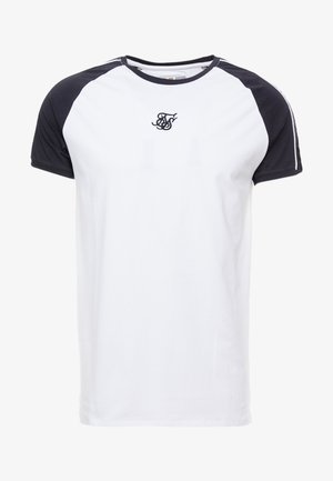 Weißes T-Shirt mit kurzen Ärmeln, schwarzen Raglanärmeln, schwarzem Kragen und kleinem schwarzen, besticktem Monogramm auf der Brust.