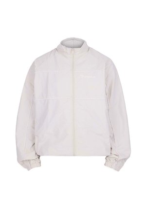 Lekka, kremowa kurtka z wysokim kołnierzem, przednim zamkiem, elastycznymi mankietami i widocznymi szwami wzdłuż klatki piersiowej.