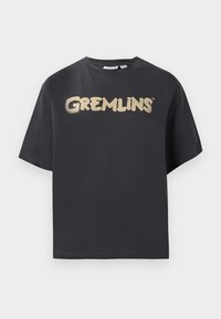 Melnas īsām piedurknēm t-krekls, izgatavots no kokvilnas, ar izteiktu zelta "GREMLINS" logotipu krūtīs rotaļīgā fontā.