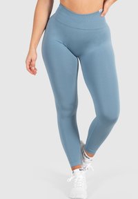 Leggings a vita alta di colore blu tenue, realizzati in un materiale liscio ed elastico. Presentano un design senza cuciture e una vita a coste.