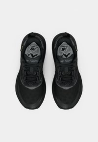 Pantofi sport negri cu parte superioară din plasă, talpă din cauciuc texturat, accente reflective și guler căptușit. Prezintă un design cu șireturi.