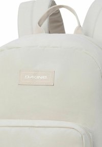 Zaino Dakine di colore crema con spalline imbottite, tasca frontale e maniglia superiore.
