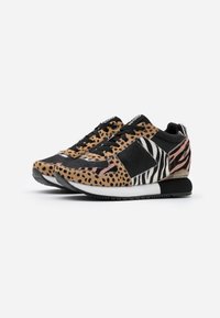 Las zapatillas con estampado de leopardo y cebra presentan una mezcla de tela en tonos marrones, negros y blancos, con cordones negros y una suela blanca.