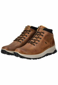 Botas de senderismo de cuero marrón con un acabado texturizado, cuello acolchado negro y suelas de goma que presentan un patrón de tracción robusto. Diseño clásico con cordones.
