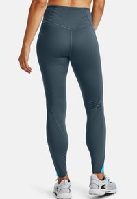 Grå leggings med hög midja och sidodetalj i blått. Slät textur och figurnära design, avsmalnande ben med kontrasterande sömdetaljer.