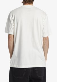 White cotton t-shirt with short sleeves, a relaxed fit, and a crew neckline. Smooth texture and no visible graphics or patterns.