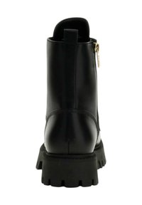 Stivale alla caviglia in pelle nera con suola robusta e zip laterale, visto da dietro su uno sfondo bianco.