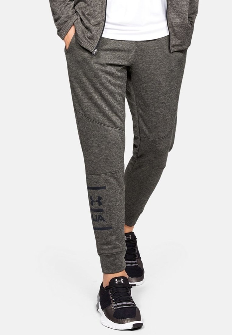 Grijze sportieve joggers van zacht materiaal, met een slim fit, zijzakken en een marineblauw Under Armour-logo langs het linkerpijp.