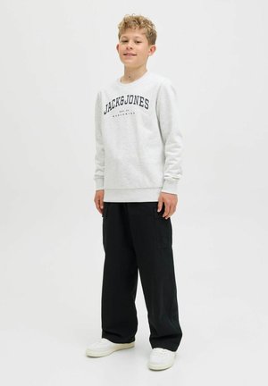 Sivá mikina s čiernym logom "JACK & JONES", kombinovaná s čiernymi cargo nohavicami a bielymi teniskami, s voľným strihom a rebrovanými manžetami.