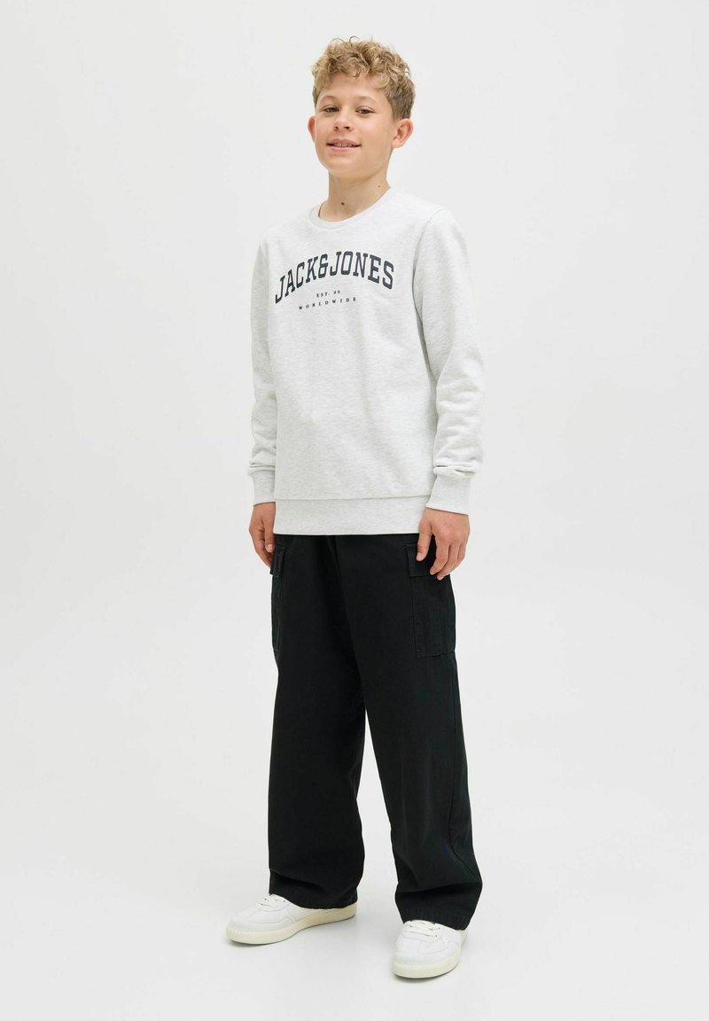 Šedá mikina s černým logem "JACK & JONES", kombinovaná s černými cargo kalhotami a bílými teniskami, se uvolněným střih a pružnými manžetami.