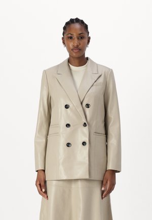 Beige faux lærjakke med doble knapper, sorte knapper, notched lapels og sidelommer. Glatt tekstur med en skreddersydd passform.