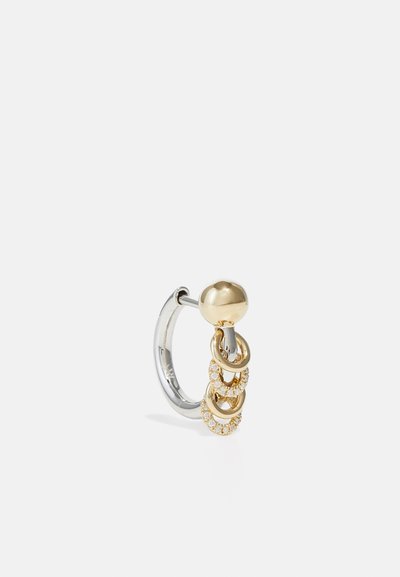 Guld- och silverfärgade metalldekorativa örhängen med tre sammankopplade ringar, varav en med klara kristaller, och ett sfäriskt topp-element.