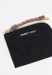 Czarna nylonowa saszetka z złotym logo "BIMBA Y LOLA". Posiada zamek błyskawiczny oraz wielokolorowy pasek z teksturowanym węzłem.