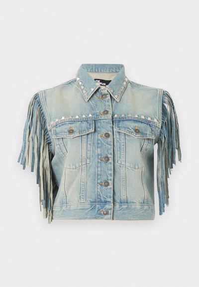 Γαλάζιο τζιν γιλέκο με κουμπιά μπροστά, ασημένιες πυραμιδωτές τρουκς στο γιακά και στο στήθος, και μακριά κρόσια στα κοντά μανίκια.