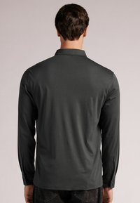 Lange mouwen shirt van donkergrijze stof met een kraag, getailleerde pasvorm, enkele knopenmanchetten en een gladde textuur. Geen zichtbare patronen.