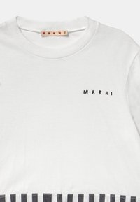 Camiseta de algodón blanca con un logo bordado en negro "MARNI" en el pecho y un patrón a rayas en blanco y negro en la parte inferior.