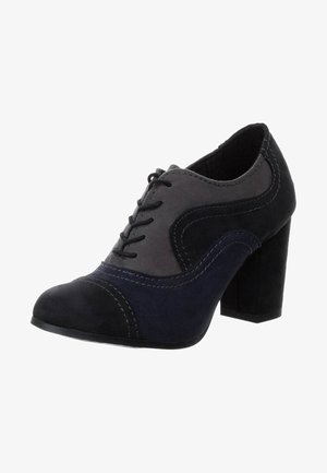 Zapatos de tacón con cordones en ante gris oscuro y azul marino, con costuras en contraste y punta redondeada. Presentan un tacón grueso y una textura suave.