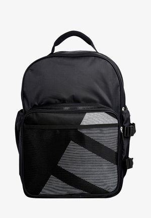 Mochila negra con gran bolsillo frontal de malla, cierres de cremallera, correas laterales y asa superior sobre un fondo blanco.